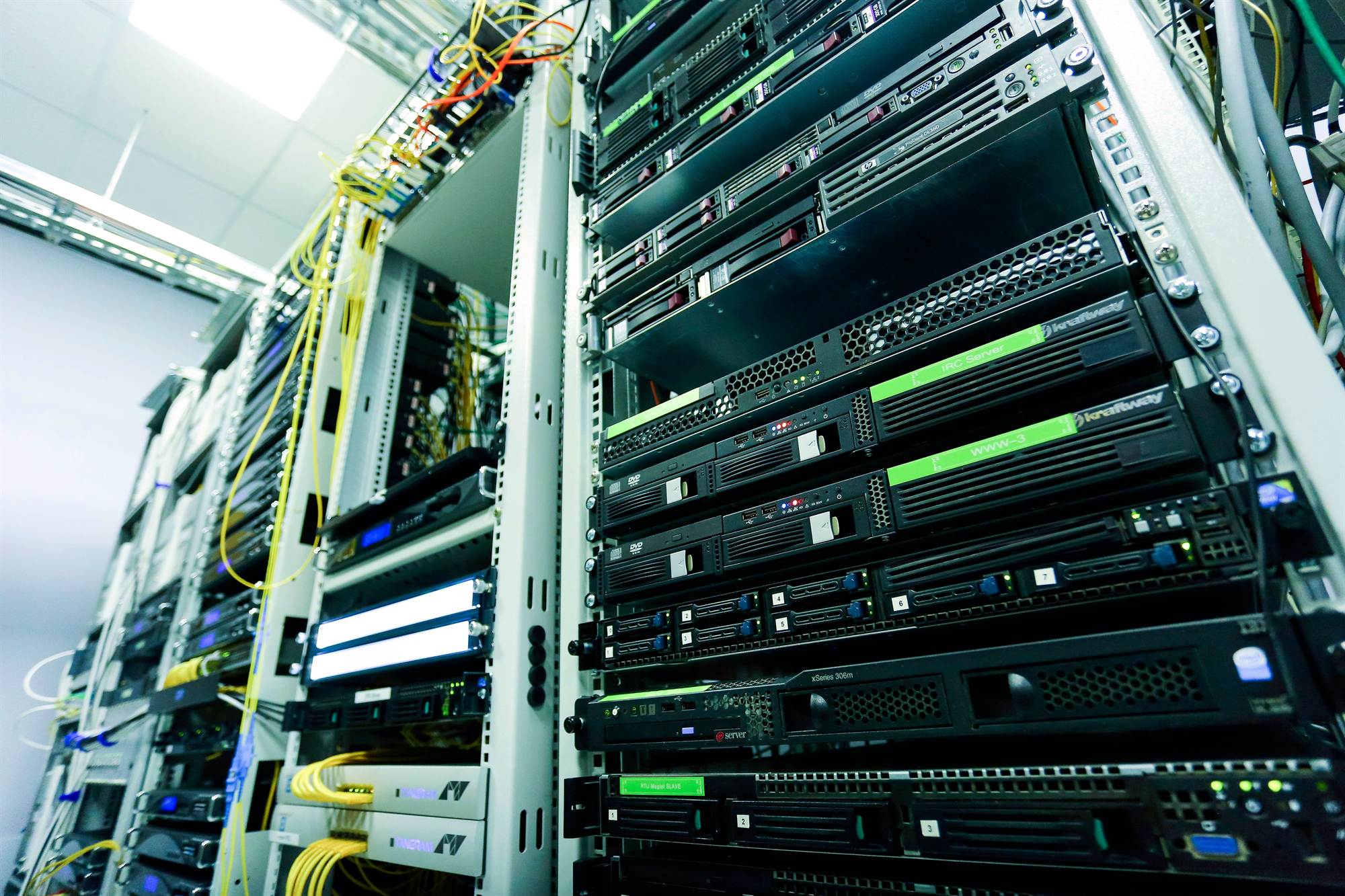 Commercial equipment room seen from below, with racked switching, servers, and dressed patch cabling
